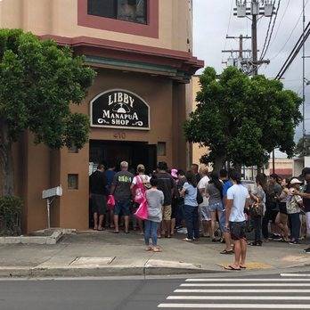 People in line outside Libby Manapua shop on a cloudy day.