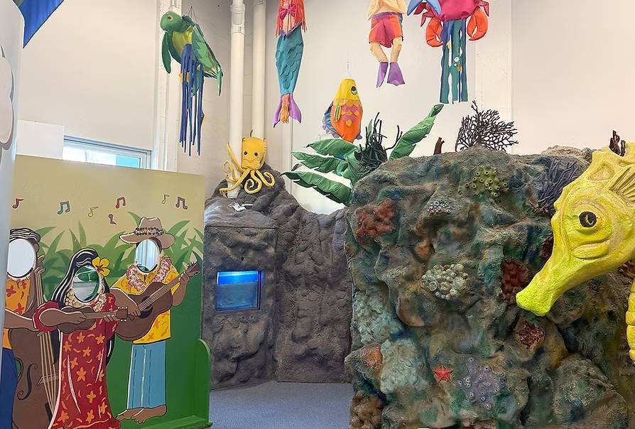 Colorful play area with ocean theme, rocks, seahorse, and animal cutouts.