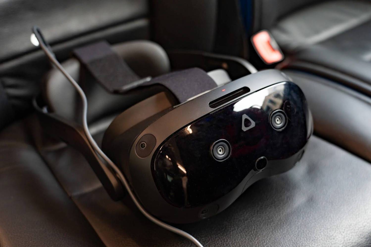 VR headset with cameras resting on a leather car seat.