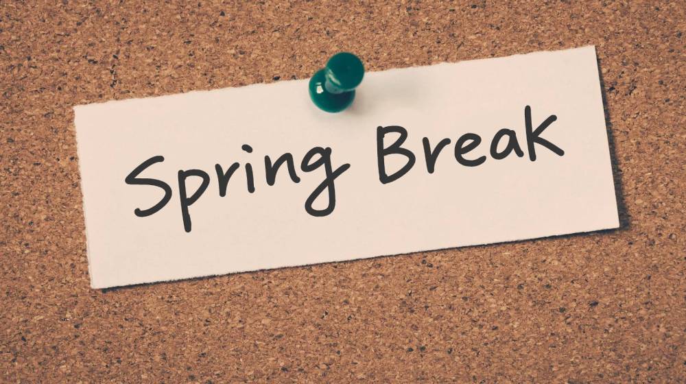 Note with 'Spring Break' pinned to corkboard with a green pushpin.