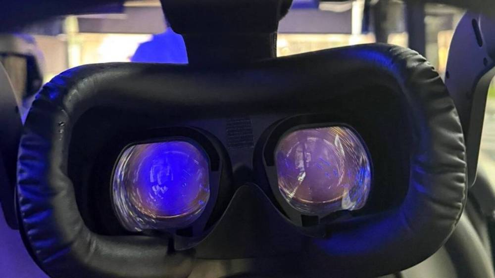 Close-up of VR headset lenses with blue light reflection.