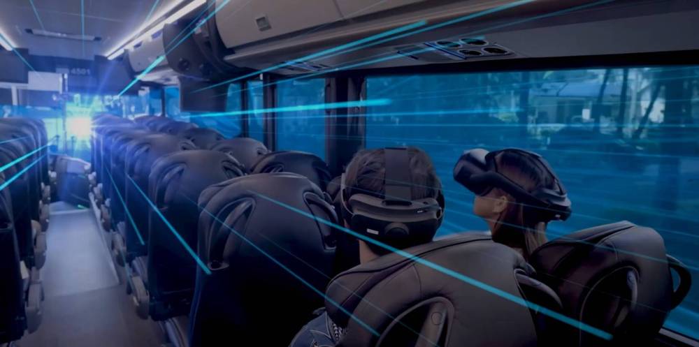 Bus passengers wearing VR headsets, blue light effects inside.