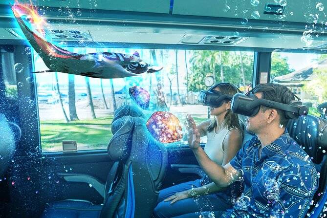 Two people on a bus using VR headsets, interacting with virtual underwater scene.