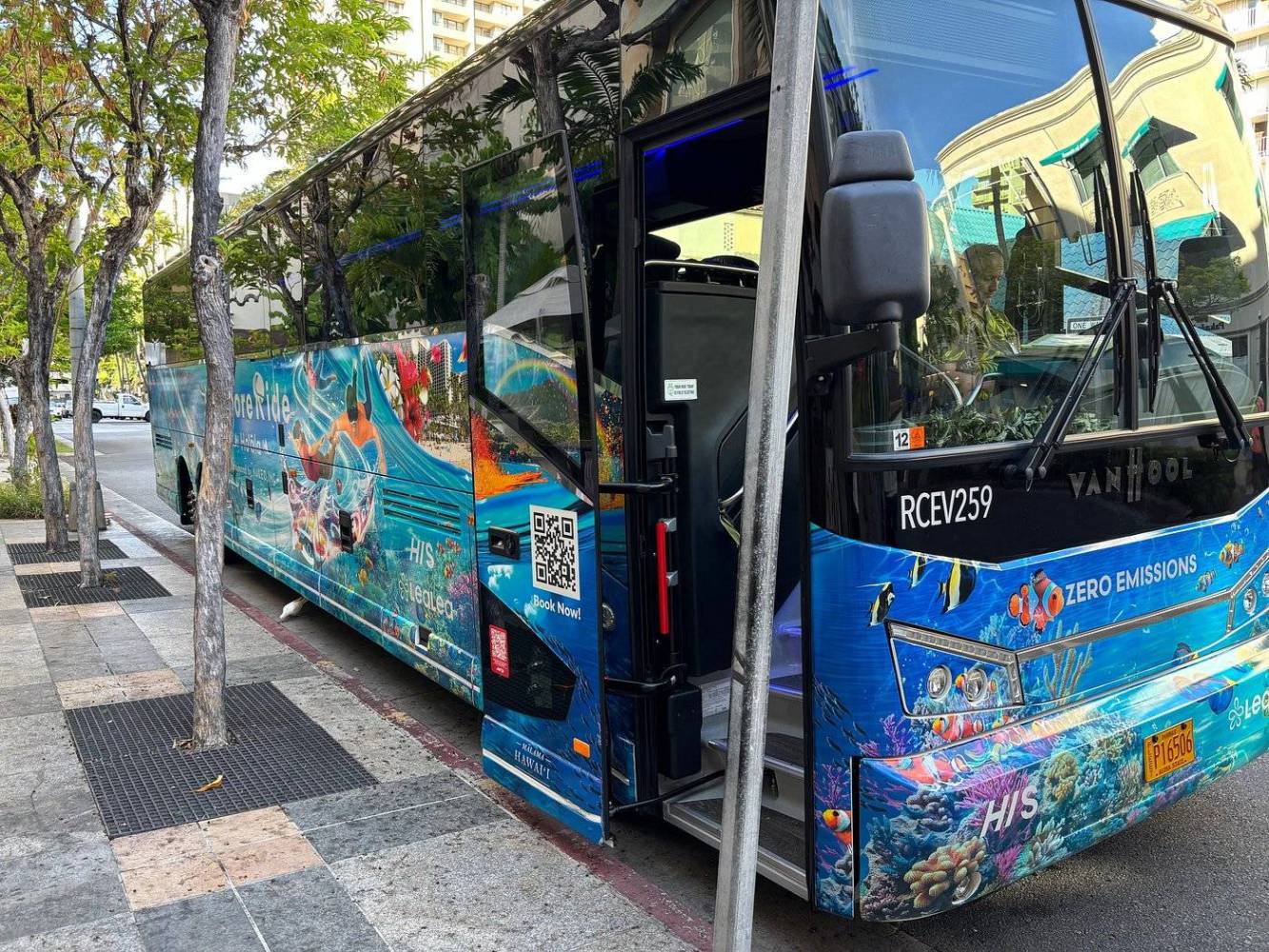 Colorful bus with ocean-themed design parked on a city street.
